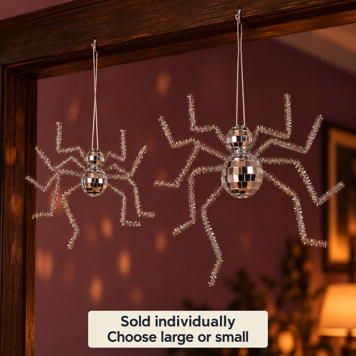 Large and small reflective silver disco spiders suspended in an indoor doorway. Sold individually; choose large or small.