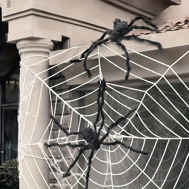 Two large black fuzzy Halloween spiders on a white web