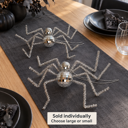 Large and small reflective silver disco spiders styled on an indoor table. Sold individually; choose large or small. Tableware and props not included.